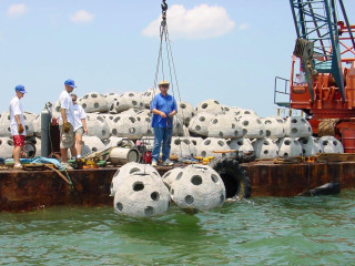 Crew members deploy reef balls into Sarasota Bay. Image courtesy SBEP